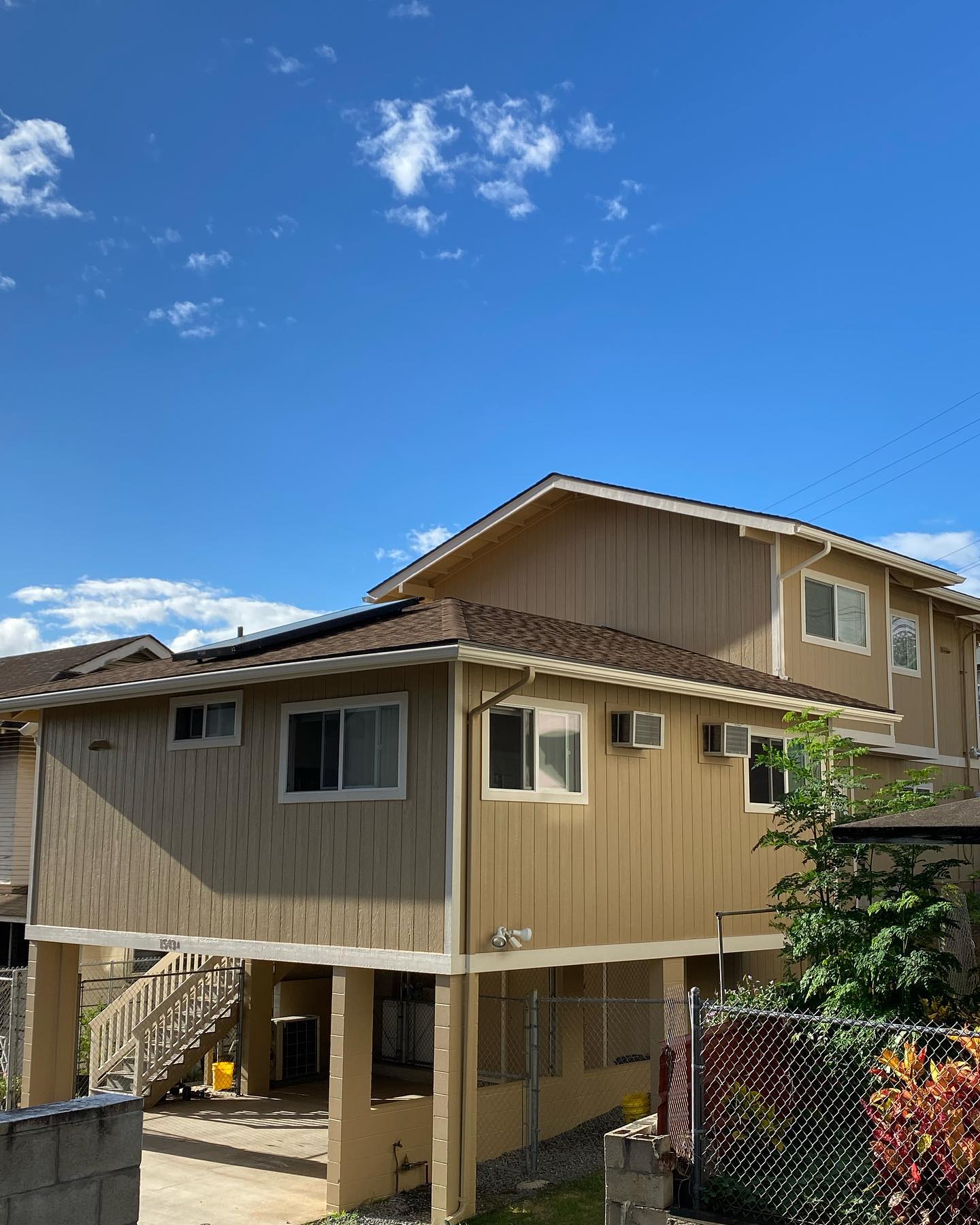 Elevated post and pier two-story home repainted in warm tan