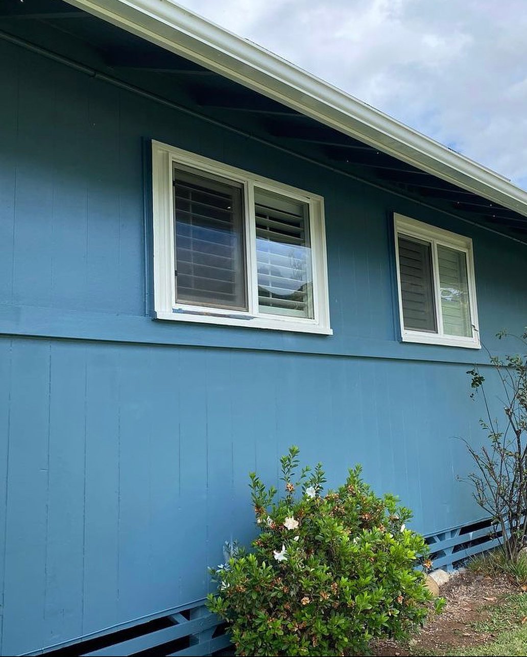 Coastal blue board-and-batten home with white window trim
