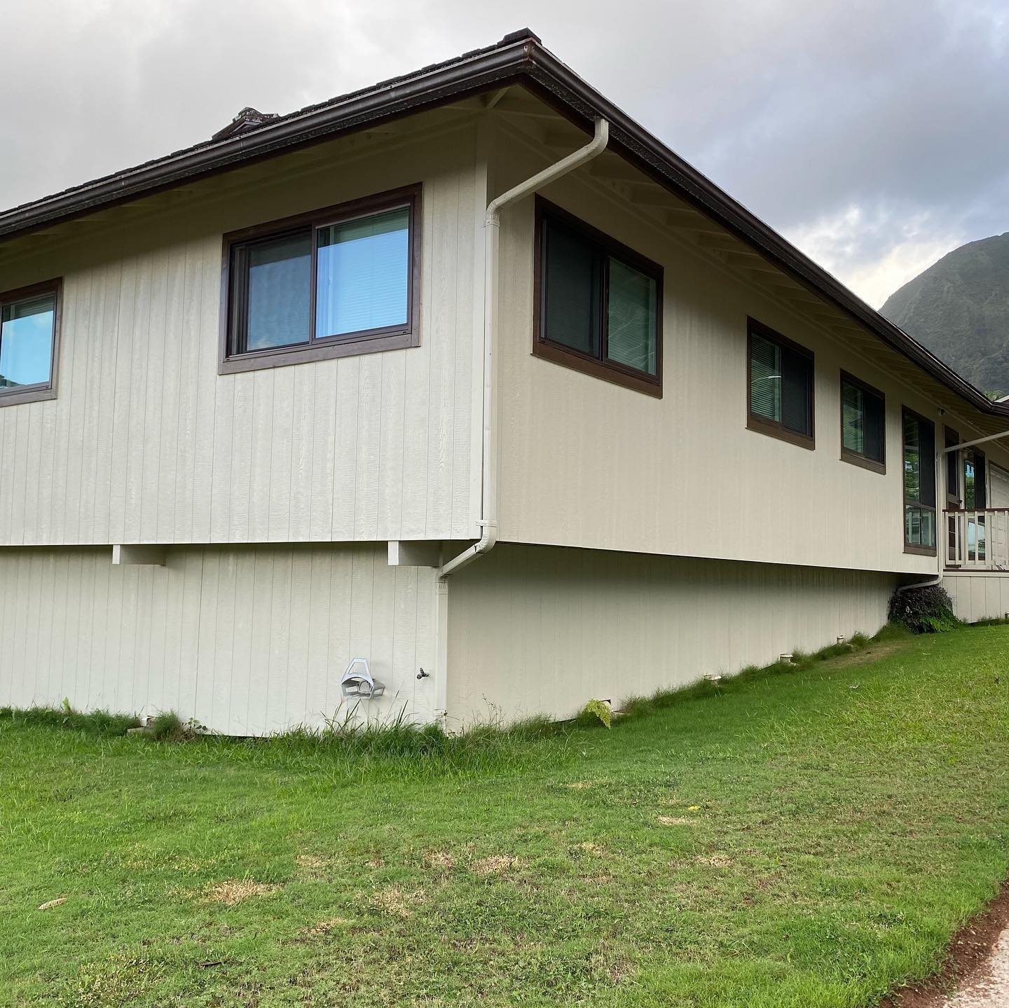 Cream and brown home with Ko'olau mountain backdrop